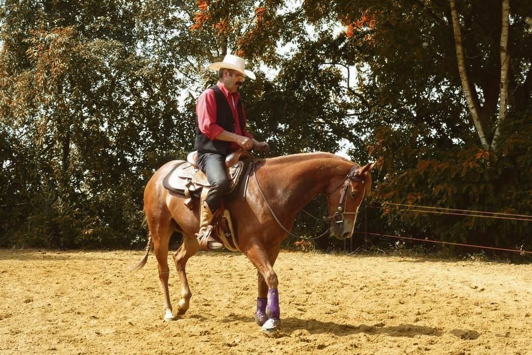 Patrick Van Coninckxloey te paard in de piste, in een rood hemd